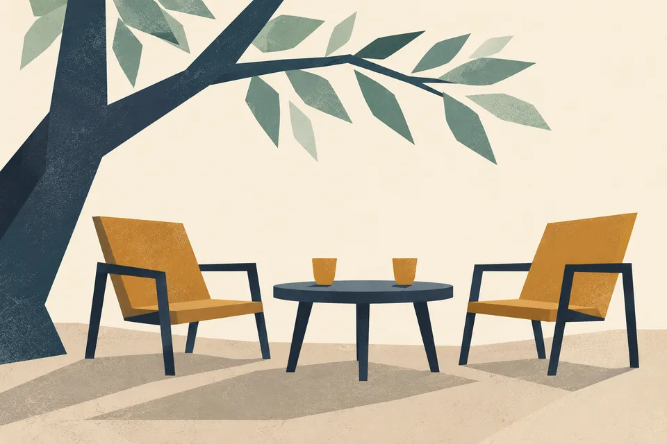 Chairs around a small table under a tree.